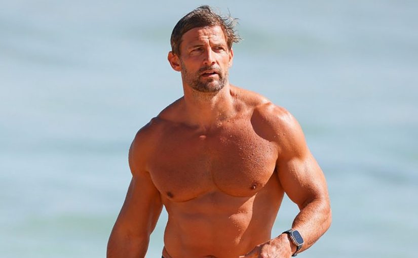 Tim Robards shows off his muscular torso on the beach