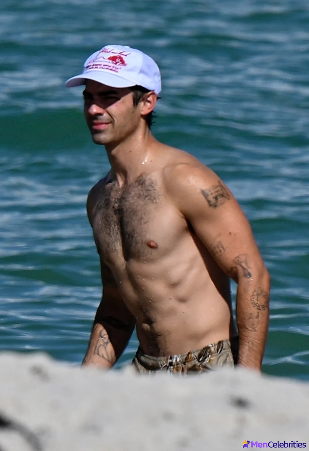 Joe Jonas shirtless on a beach